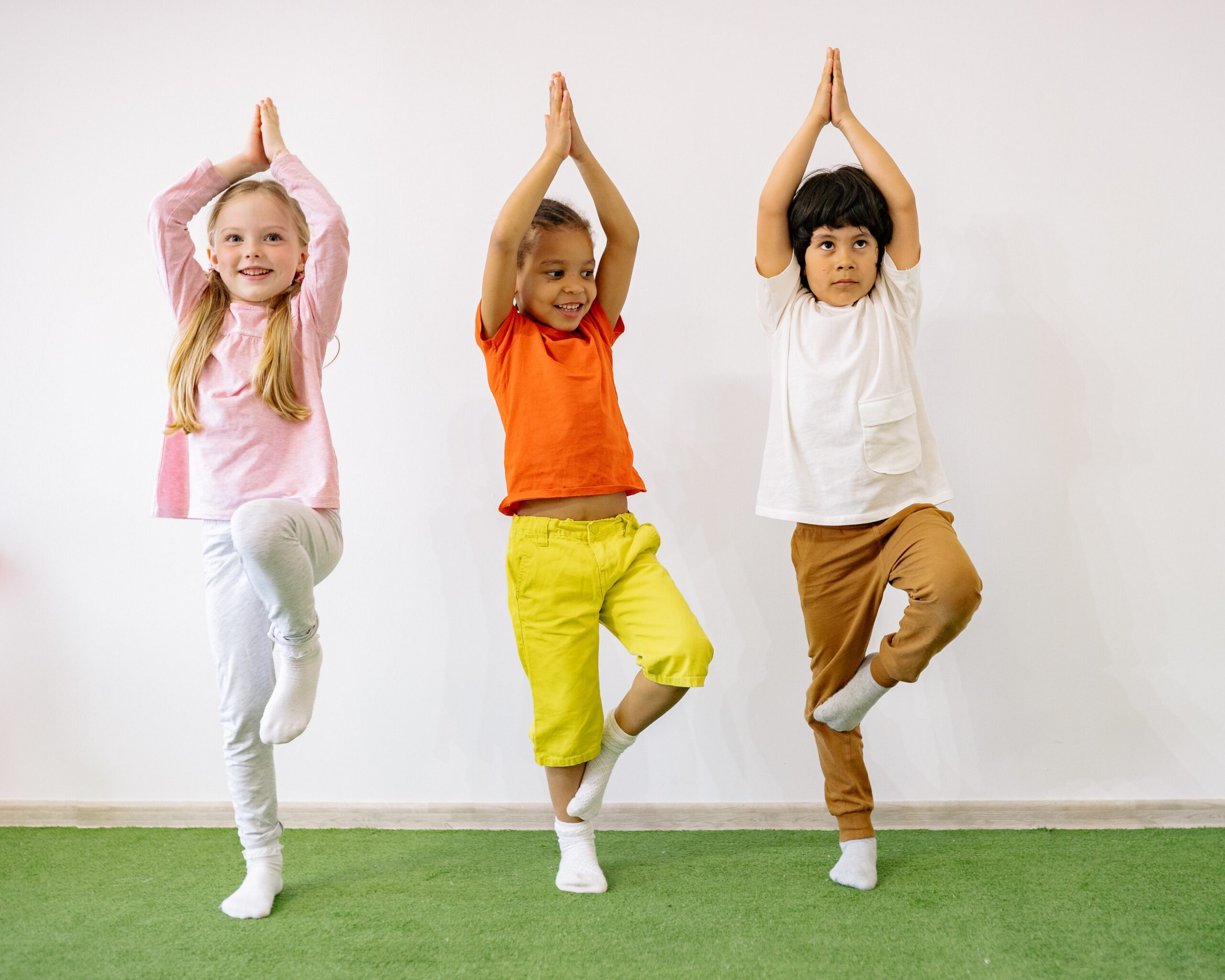 3 young children hold gymnastic balance pose.