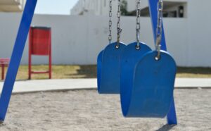 Empty swings in a playground.
