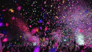 People throwing multi-coloured confetti in the air in celebration