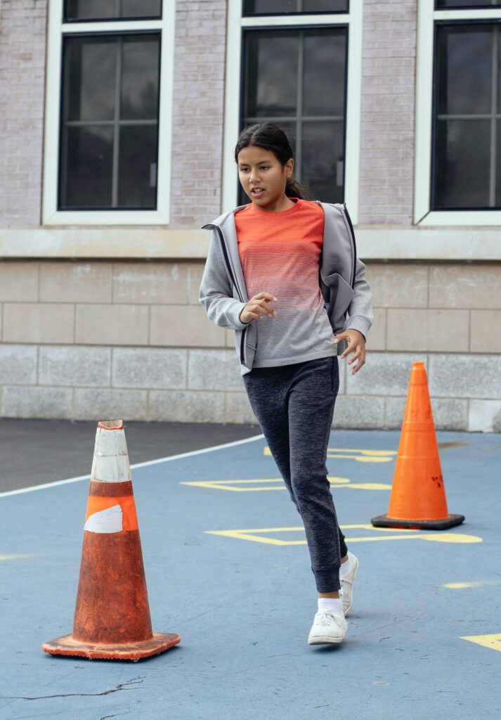 Girl running around cones in PE lesson.